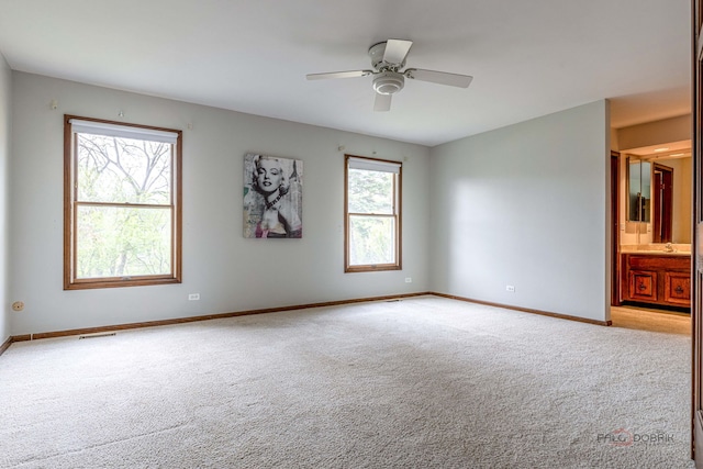 spare room featuring baseboards, carpet, a ceiling fan, and visible vents
