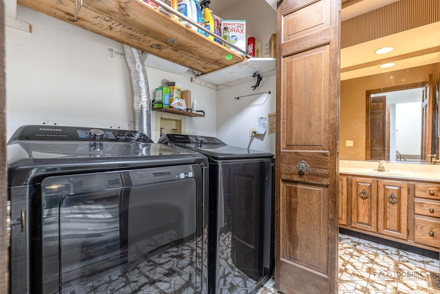 washroom with laundry area, a sink, and washing machine and dryer