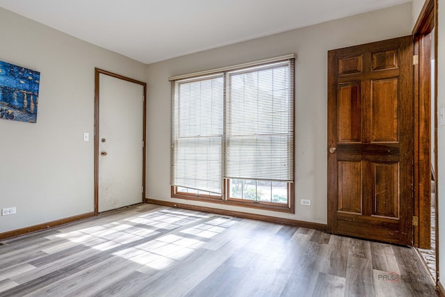 foyer with baseboards and light wood-style flooring