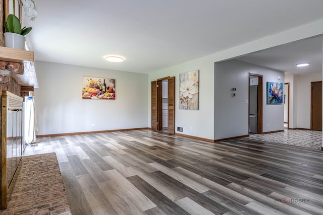 unfurnished living room featuring baseboards and wood finished floors
