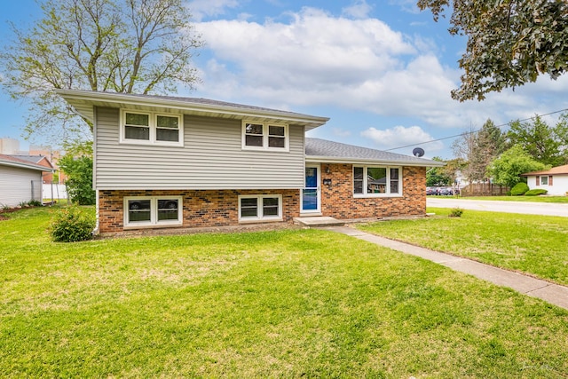 split level home with brick siding and a front yard