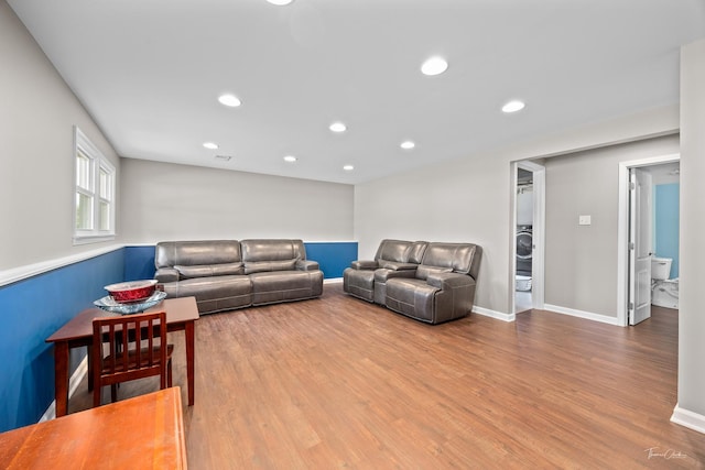 living room featuring wood finished floors, stacked washer and clothes dryer, recessed lighting, and baseboards