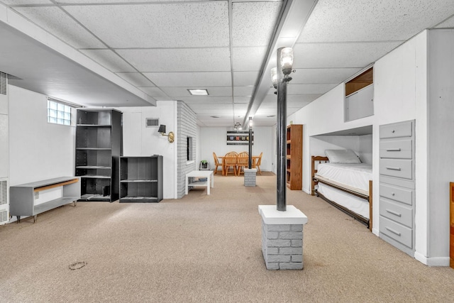 basement with carpet floors and a paneled ceiling