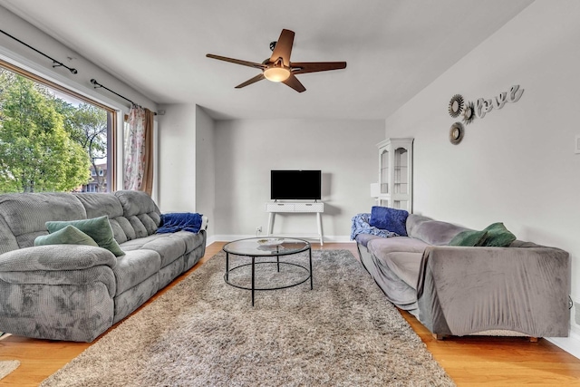 living room featuring ceiling fan, wood finished floors, and baseboards