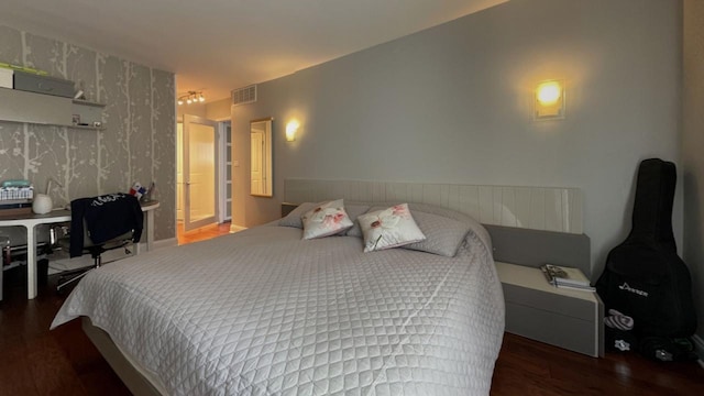 bedroom featuring wood finished floors and visible vents