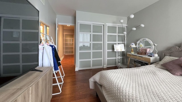 bedroom with dark wood-type flooring and baseboards
