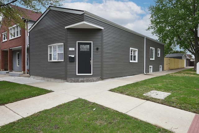 view of front of house featuring fence and a front lawn