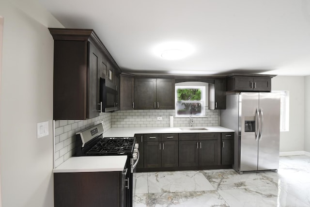 kitchen with a sink, decorative backsplash, appliances with stainless steel finishes, and light countertops
