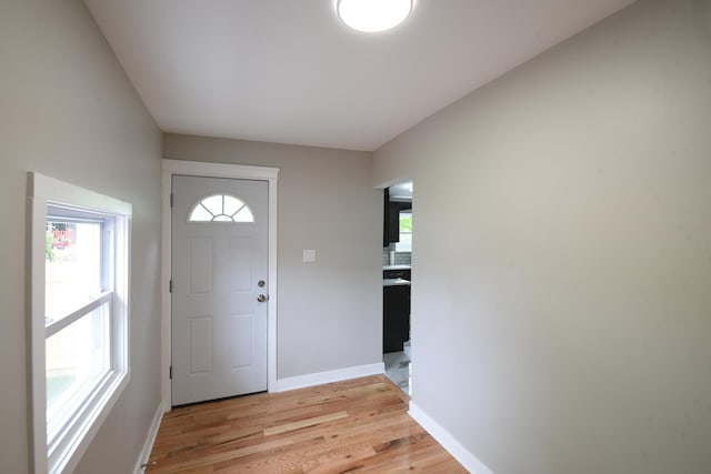 foyer entrance featuring baseboards and light wood-style flooring