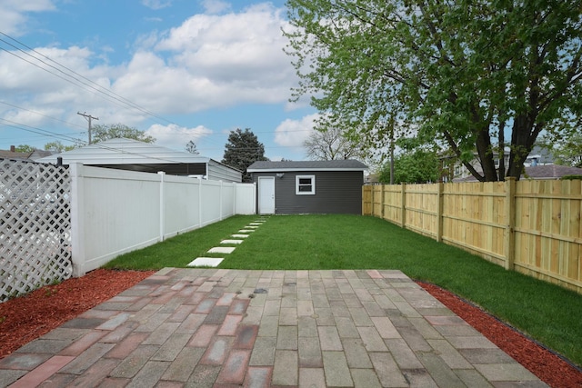 view of yard featuring an outdoor structure, a patio, and a fenced backyard