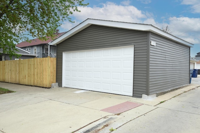 detached garage featuring fence