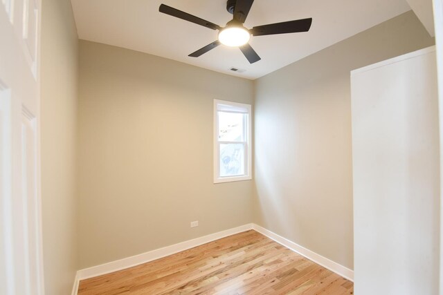 unfurnished room featuring light wood-style floors, a ceiling fan, baseboards, and visible vents