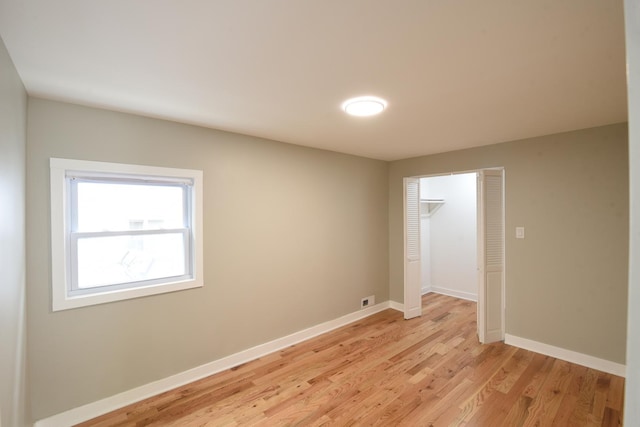 spare room featuring baseboards and light wood-style floors