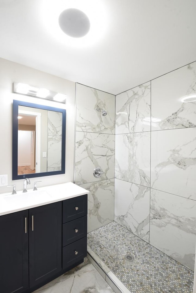 bathroom featuring vanity, tiled shower, and marble finish floor