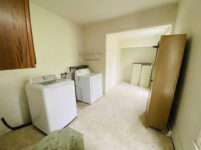 clothes washing area with light floors, laundry area, and washer and dryer