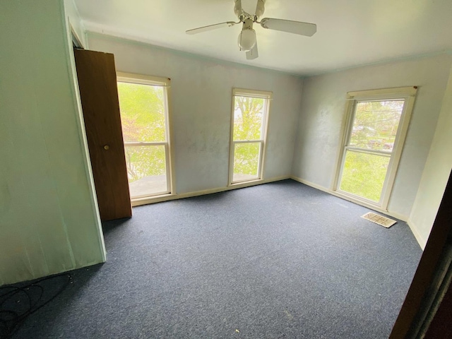 spare room with a healthy amount of sunlight, ceiling fan, and carpet floors