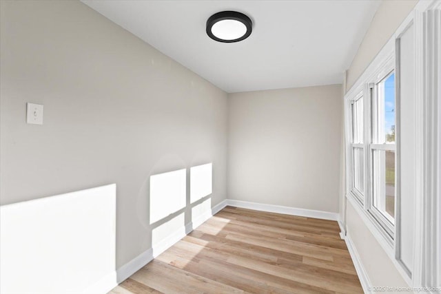 empty room featuring baseboards and light wood-style floors