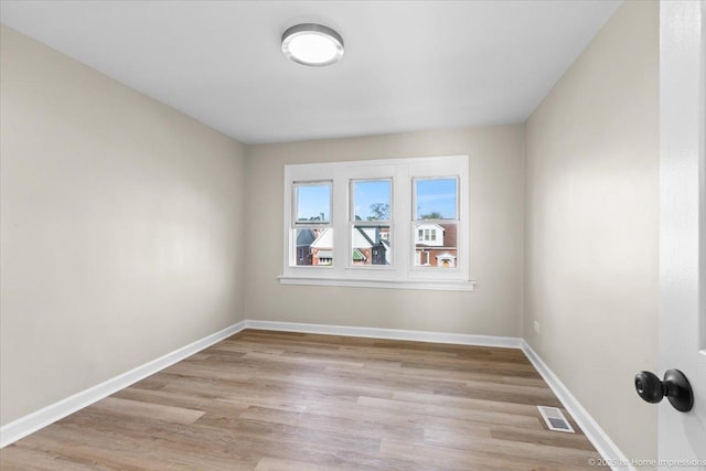 empty room with baseboards, light wood-style flooring, and visible vents