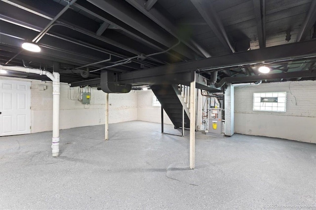 below grade area featuring stairs, heating unit, and electric panel
