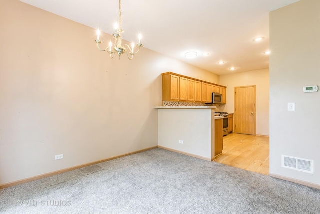 kitchen with visible vents, light carpet, baseboards, a chandelier, and stainless steel appliances