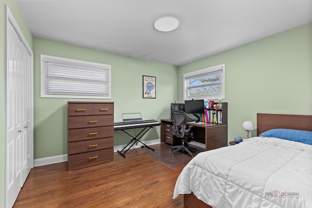 bedroom with baseboards, wood finished floors, and a closet