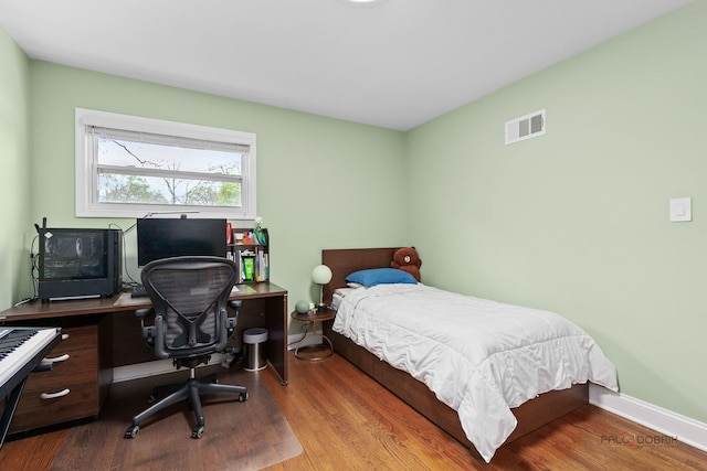 bedroom featuring wood finished floors and visible vents
