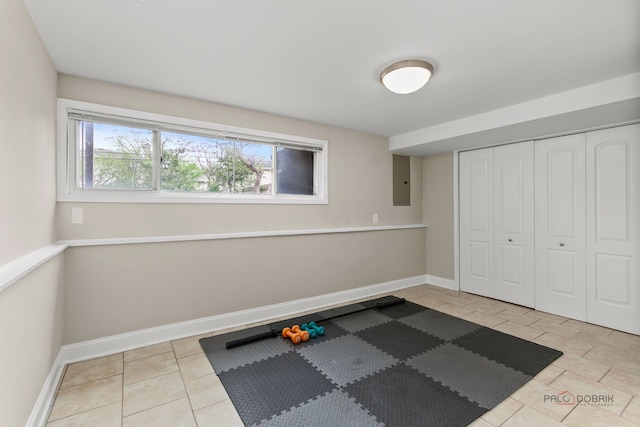 workout room featuring tile patterned floors, baseboards, and electric panel