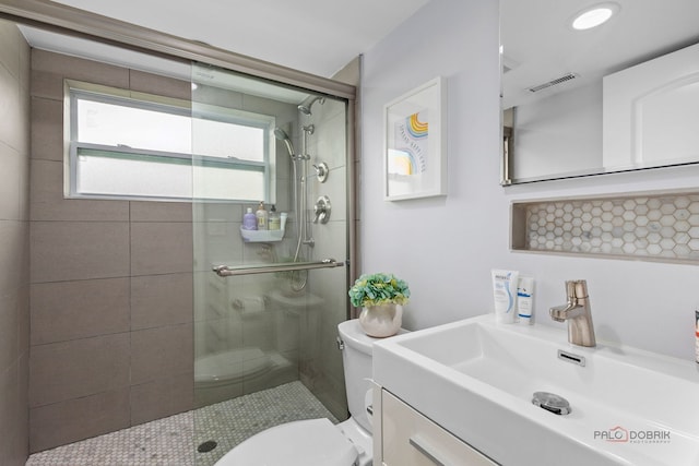 bathroom featuring visible vents, a stall shower, toilet, and vanity