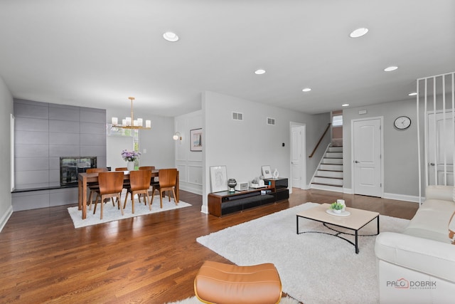 living room featuring visible vents, recessed lighting, stairs, and wood finished floors