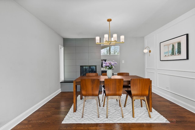 dining room with an inviting chandelier, baseboards, and wood finished floors