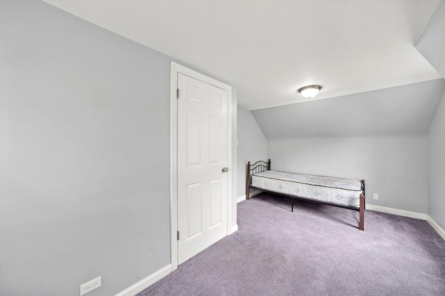 unfurnished bedroom featuring carpet floors, baseboards, and vaulted ceiling