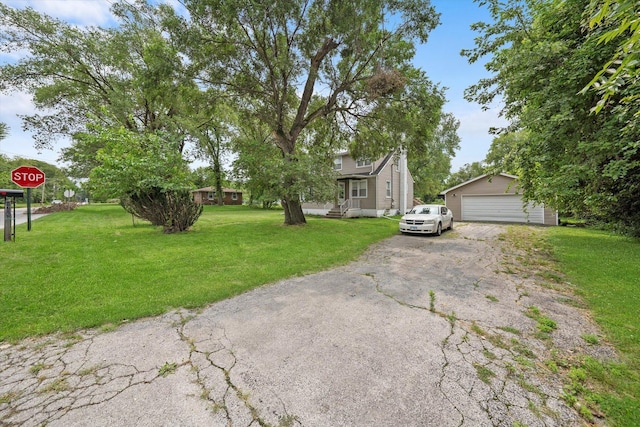 view of property hidden behind natural elements featuring a detached garage, an outbuilding, and a front lawn