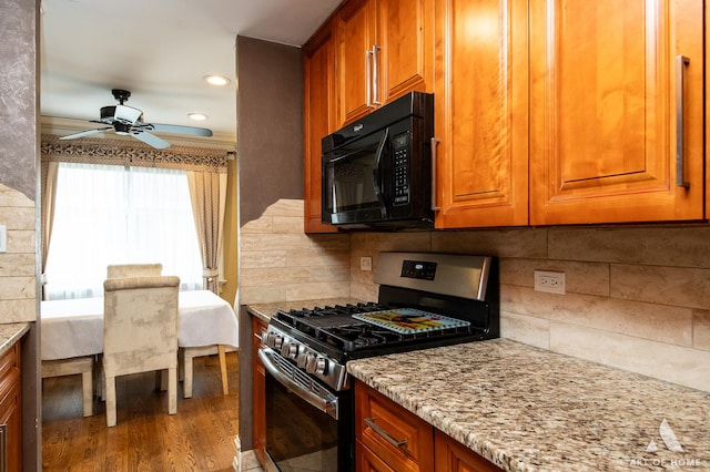 kitchen with black microwave, brown cabinetry, and gas range