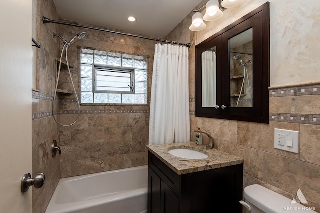 bathroom featuring vanity, tile walls, toilet, and shower / bathtub combination with curtain