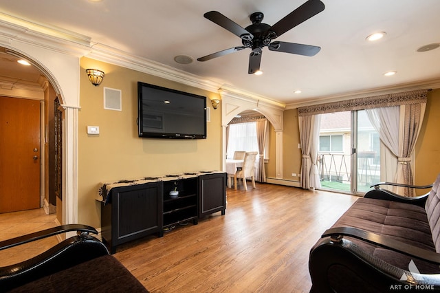 living room with crown molding, ceiling fan, a baseboard heating unit, and light wood-type flooring