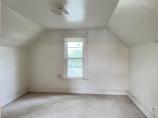 bonus room with baseboards, light colored carpet, and lofted ceiling