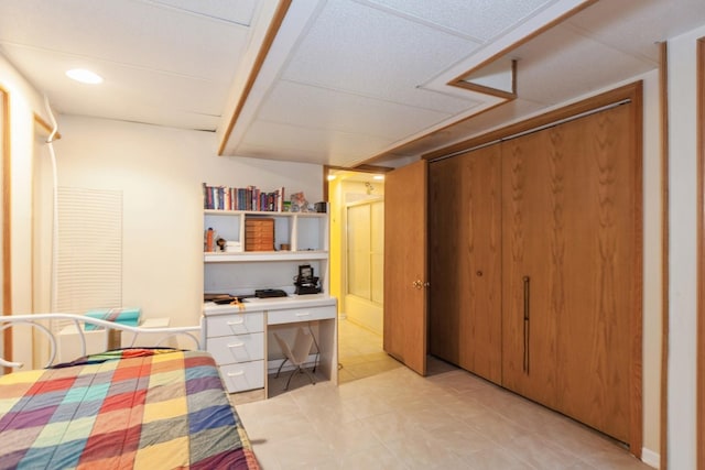 bedroom with a closet, built in desk, and light tile patterned floors