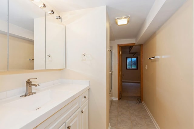 bathroom with tile patterned floors, baseboards, a shower with shower door, and vanity