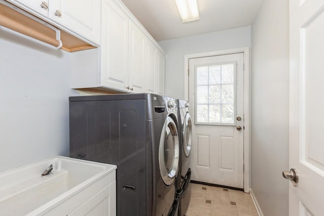 laundry room featuring cabinet space, a sink, separate washer and dryer, baseboards, and light tile patterned floors