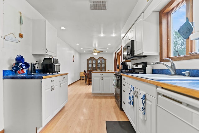 kitchen featuring visible vents, stainless steel range with gas stovetop, dishwasher, a sink, and white cabinetry