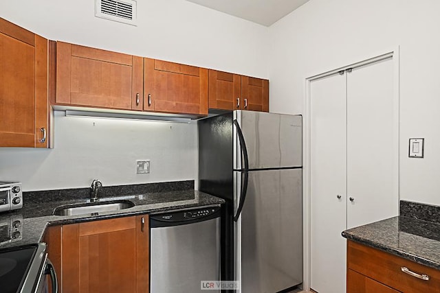 175 E Delaware Pl Unit 5019, Chicago, IL 60611 - kitchen featuring stainless steel appliances, a sink, brown cabinetry, and dark stone counters