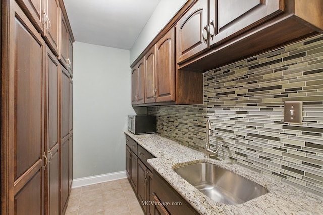 12652 Suffield Dr, Palos Park, IL 60464 - kitchen with decorative backsplash, light stone countertops, baseboards, stainless steel microwave, and a sink