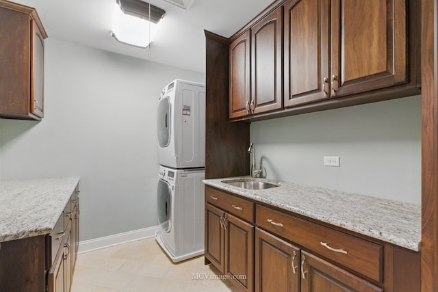 12652 Suffield Dr, Palos Park, IL 60464 - clothes washing area with cabinet space, baseboards, a sink, and stacked washer and clothes dryer