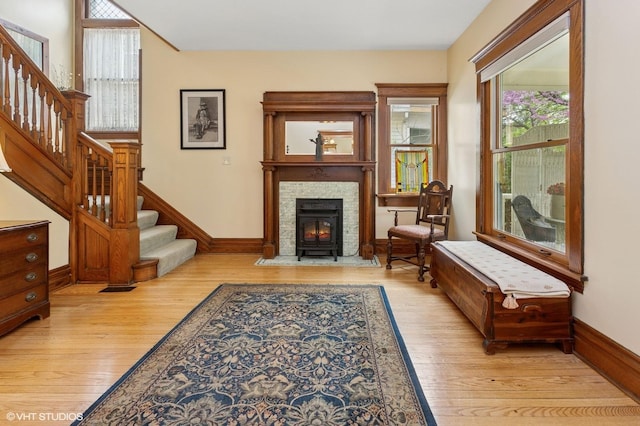 317 Augusta Ave, Dekalb, IL 60115 - living area featuring light wood-type flooring, stairway, baseboards, and a fireplace with flush hearth