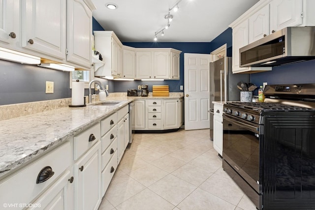317 Augusta Ave, Dekalb, IL 60115 - kitchen with light tile patterned floors, a sink, stainless steel appliances, white cabinetry, and light stone counters