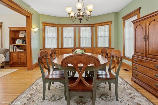 317 Augusta Ave, Dekalb, IL 60115 - dining room with baseboards, a notable chandelier, light wood-type flooring, and visible vents