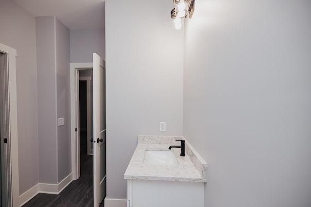 bathroom featuring baseboards, wood finished floors, and vanity