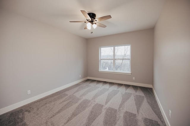 carpeted empty room with baseboards and a ceiling fan