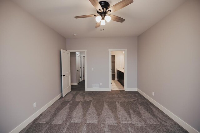 unfurnished bedroom featuring ceiling fan, ensuite bath, carpet floors, baseboards, and visible vents