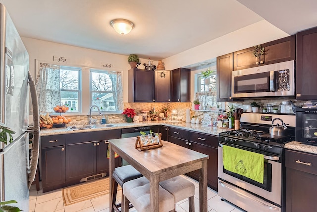 kitchen with a sink, appliances with stainless steel finishes, plenty of natural light, and backsplash